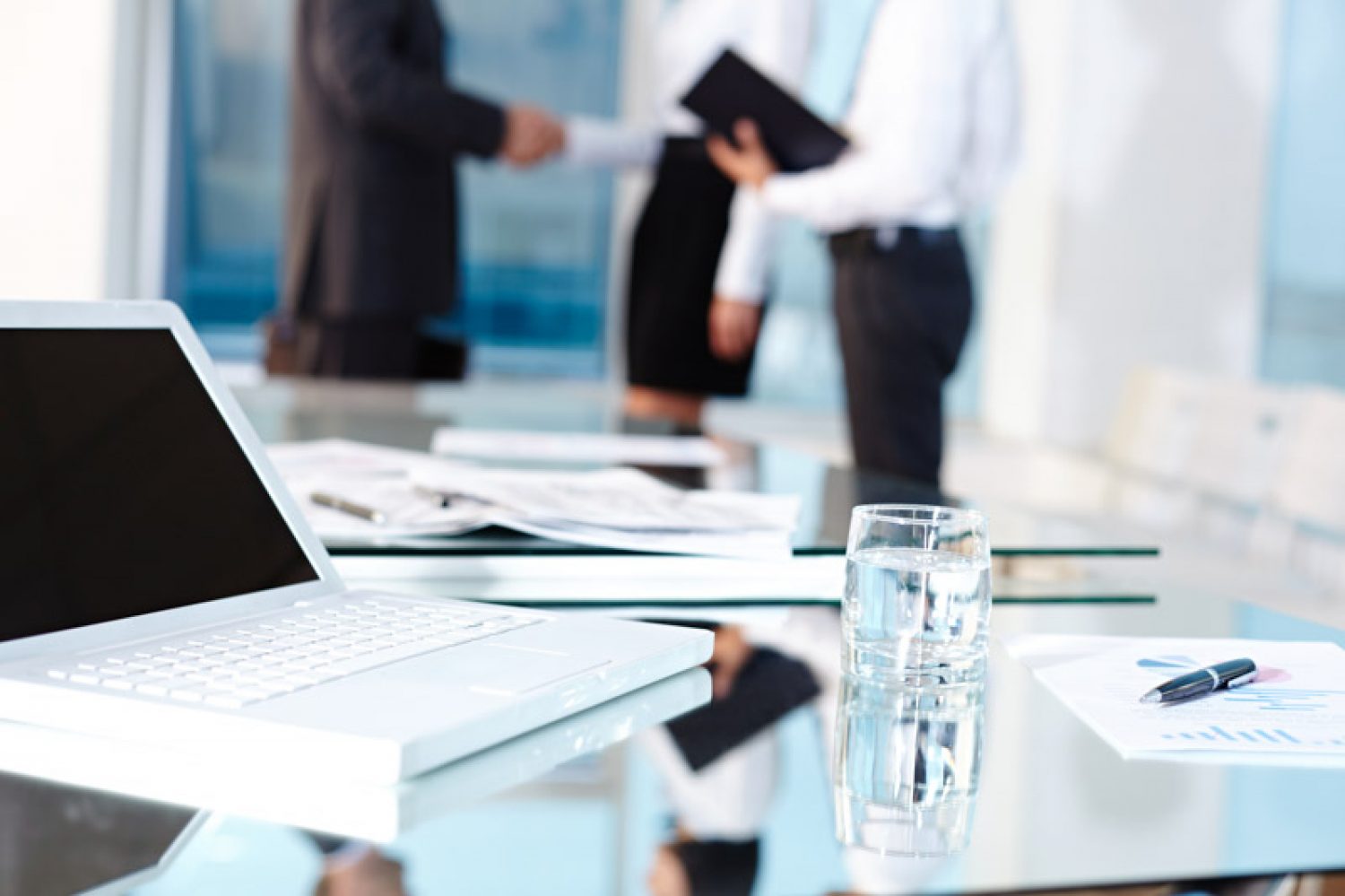 Laptop and glass on table